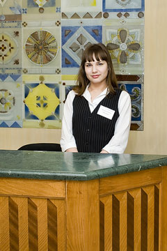 hotel reception desk clerk, with elegant, green marble desktop